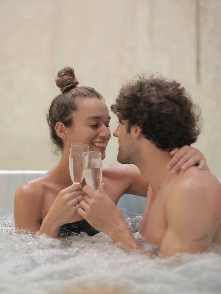Couple-in-bathtub-enjoying-a-glass-of-wine-happily